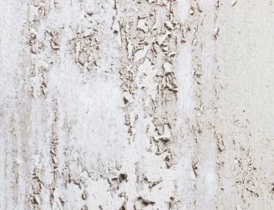 Peeling paint on a wall indicating excessive moisture damage, highlighting indoor air quality concerns related to mold and mildew.