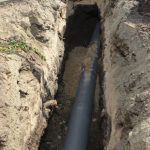 Trench exposing a sewer pipe for repair or replacement, illustrating the sewer line repair process by Warhold Plumbing, Heating and Air Conditioning in Irwin, PA.